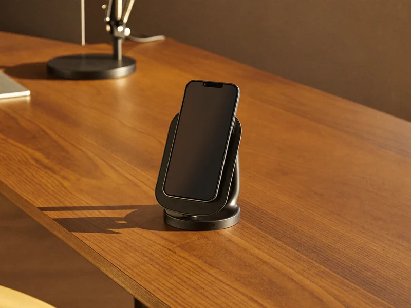 Stand magnetic de încărcare cu telefon pe un birou din nuc